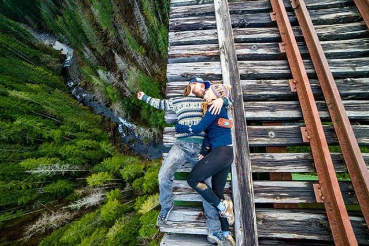 pareja acostada en la orilla de un puente 