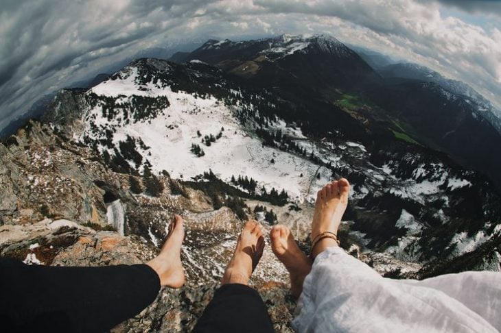 pies de pareja en la cima de una montaña