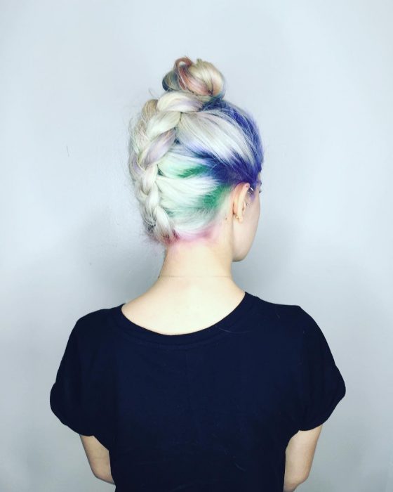 Chica con las raíces del cabello teñidas en colores azul, rosa, verde y morado 