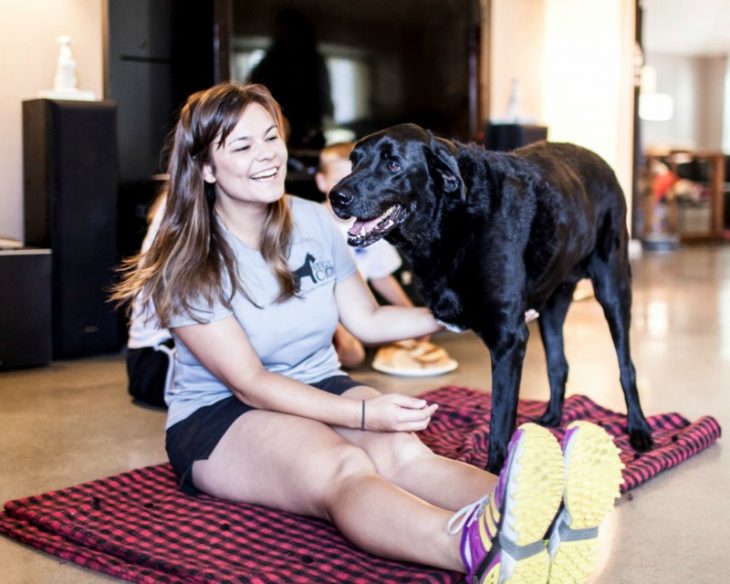 mujer sonriendo con un perro con 3 patas 