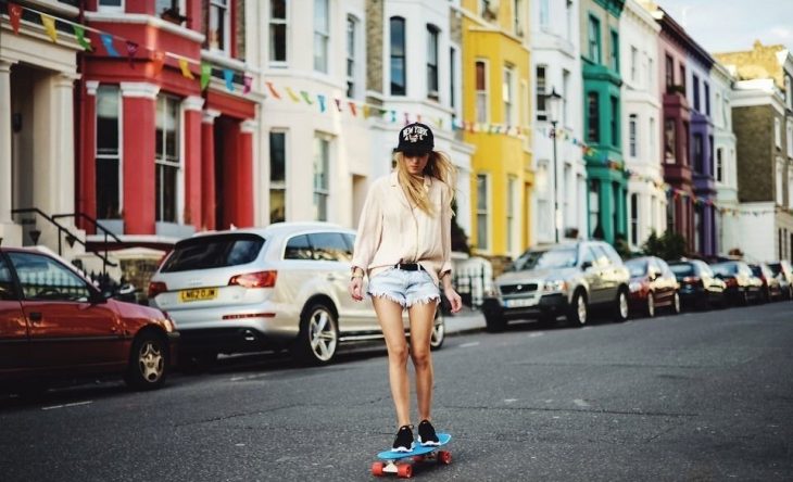 chica en patineta en la calle mirando hacia abajo