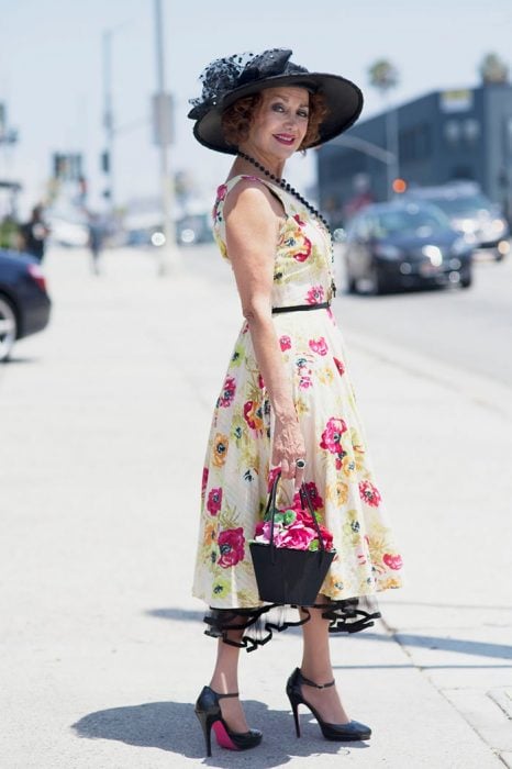 Mujer mayor usando un vestido de flores, sombrero y tacones