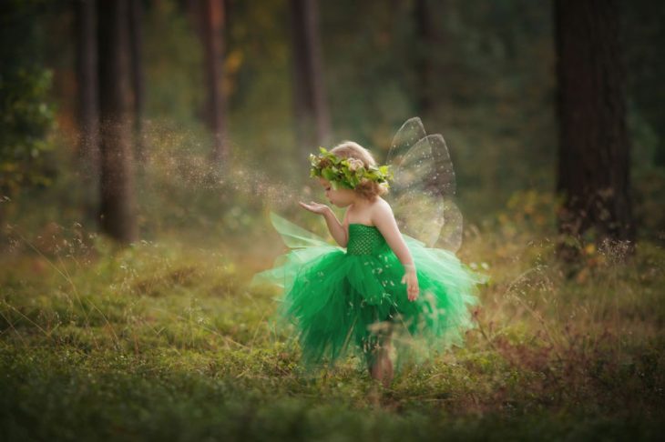 Niña disfrazada de hada en el bosque 