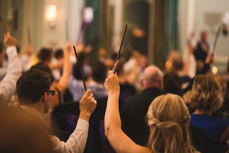 Invitados de una boda agitando sus varitas mágicas 