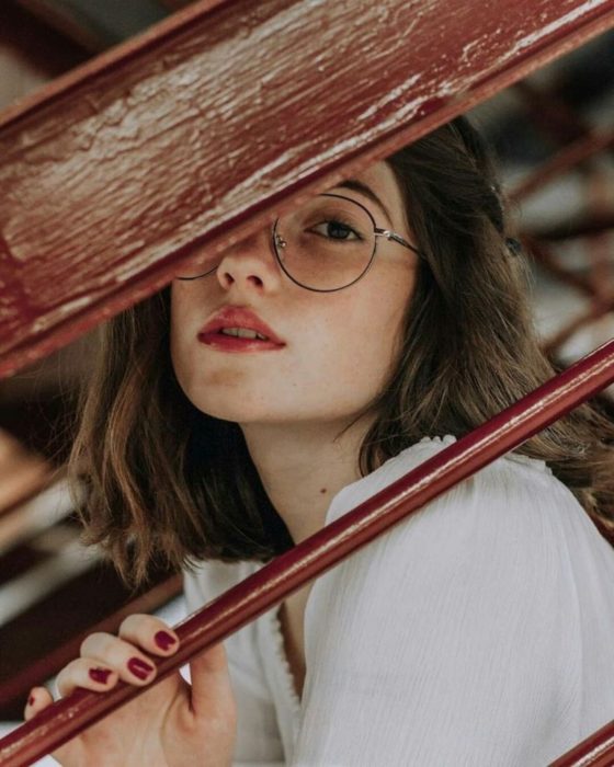 Personalidad de chica sagitario; mujer de cabello castaño corto con lentes de aumento