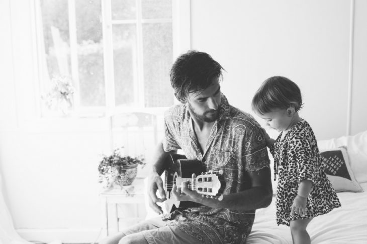 Padre tocando la guitarra para su hija 