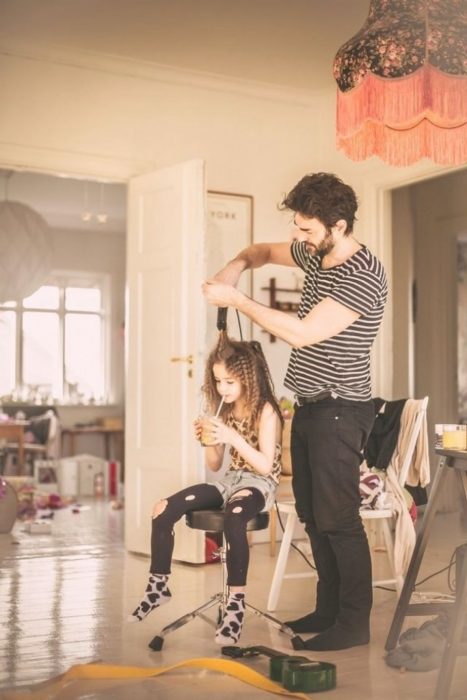 Papá peinando a su hija con bucles 