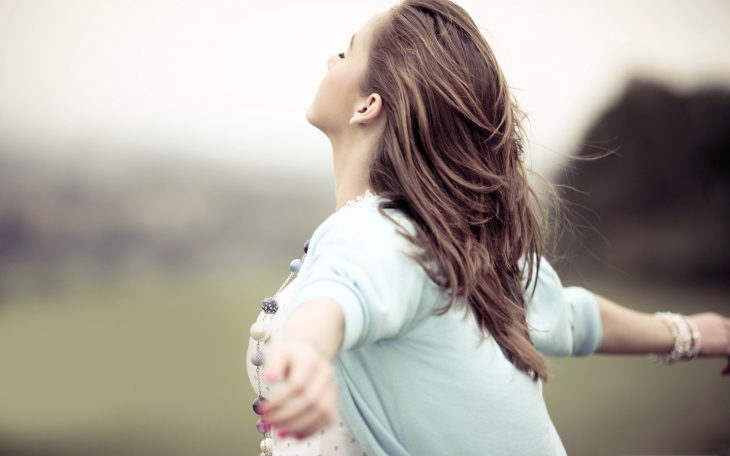 chica abriendo los brazos en el campo