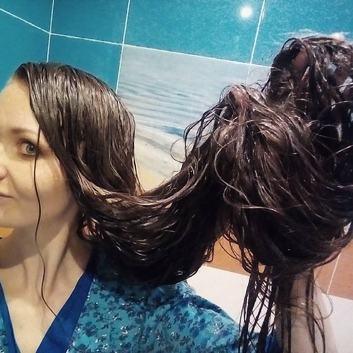 Chica mostrando su cabello trenzado luego de tomar una ducha 