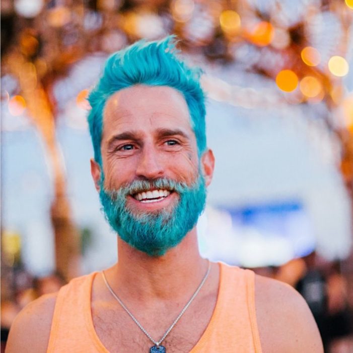 Hombre con el cabello y barba pintada de azul 