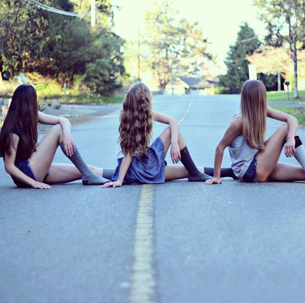 Chicas sentada en la carretera con las piernas cruzadas 