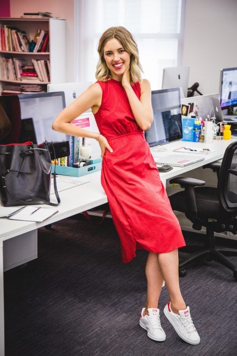 Chica usando un vestido de color rojo con zapatillas de color blanco 