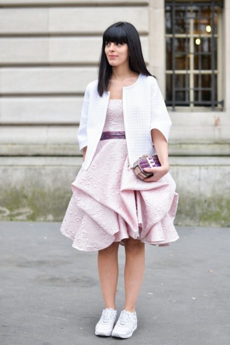 Chica usando un vestido en color rosa y unas zapatillas en color blanco 