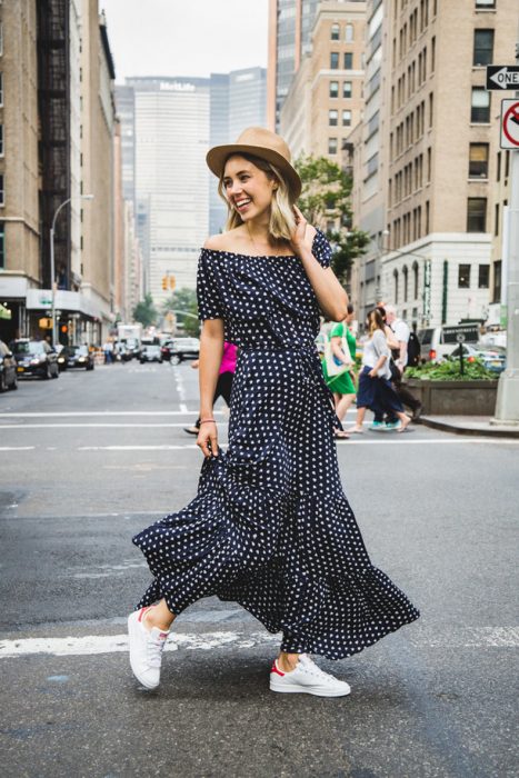 Chica usando un vestido y sombrero junto con unas zapatillas en color blanco 