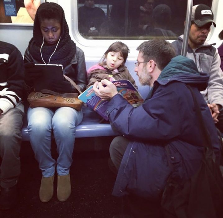 PAPÁ LEYENDOLE EN EL METRO A SU HIJA