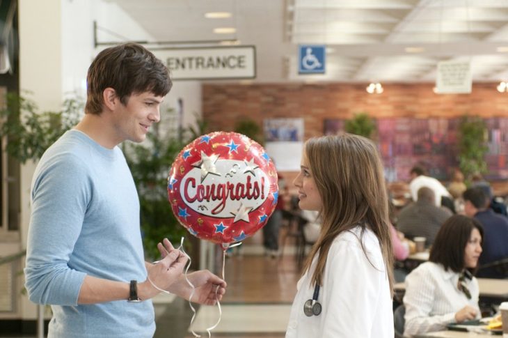 hombre con globo sonrie enfrente de mujer