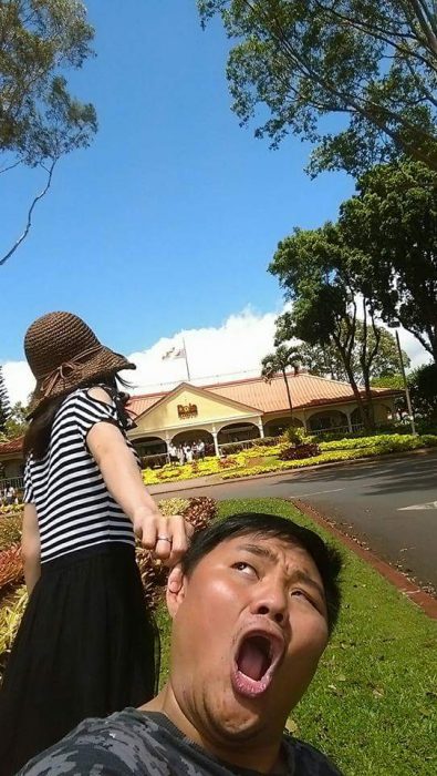 Chica tomando de una oreja a su pareja mientras caminan por Hawai 