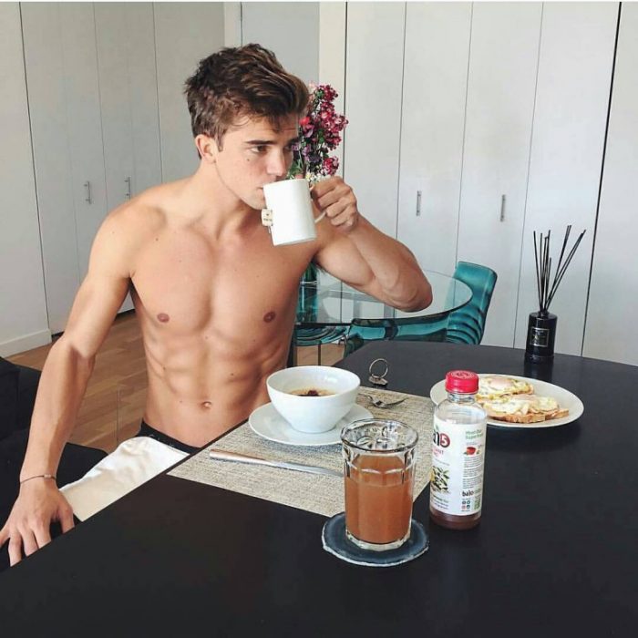 hombre musculoso sentado desayunando 