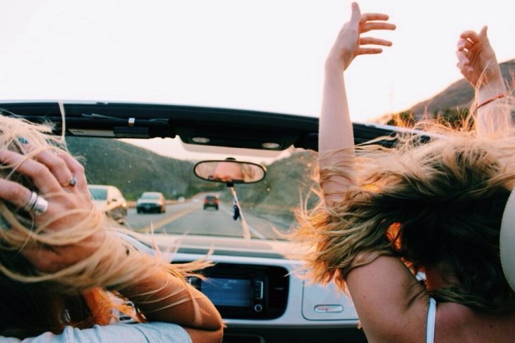 Chicas viajando en un coche convertible 