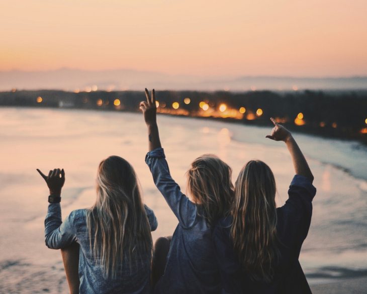 Chicas viendo el atardecer frente al mar 