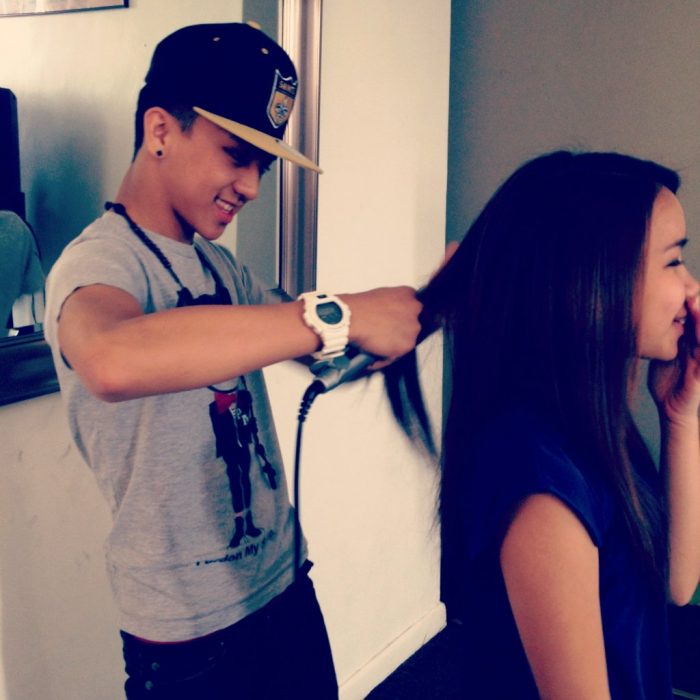 Chico planchando el cabello de una chica