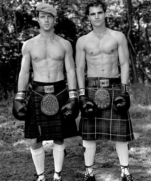 Chicos con guantes de box vistiendo una falda escocesa 