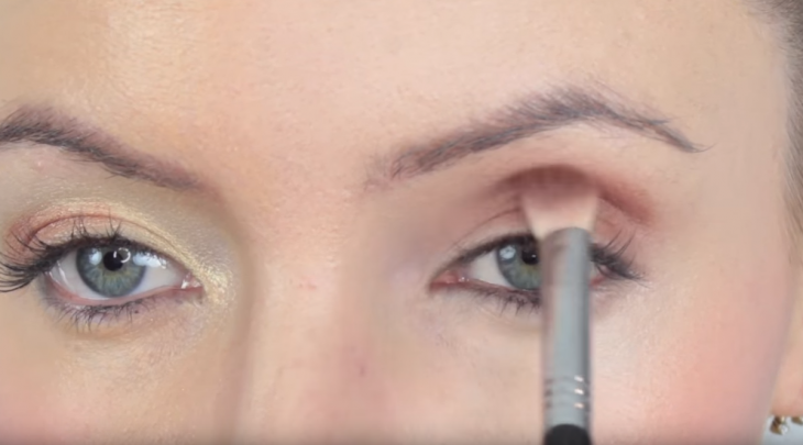 mujer maquillando los ojos con brocha 