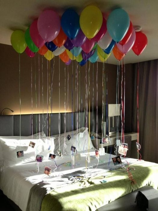 cama con globos y fotografias colgando