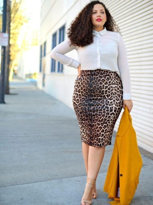 Chica curvy modelando una falda de leopardo y blusa blanca