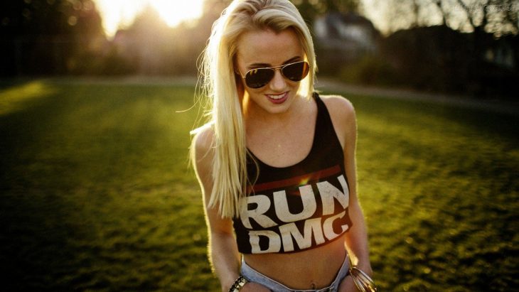 Mujer rubia en el atardecer con una camiseta que dice RUN DMC