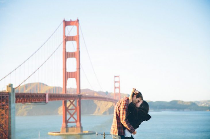 pareja abrazando y besandose en puente de sanfrancisco