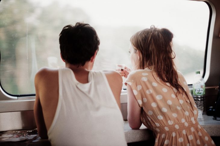 pareja platicando frente a una ventana 