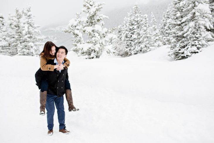 hombre carga a mujer en campo nevado