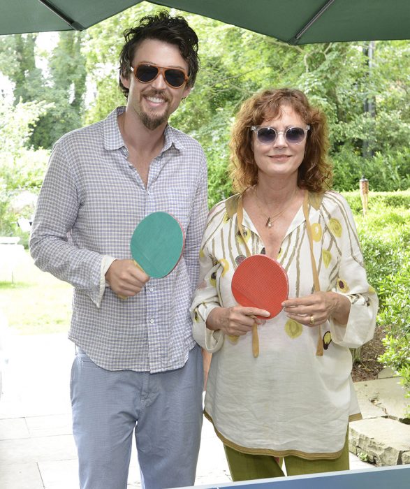 mujer con lentes y raquetas de ping pong y hombre a un lado 