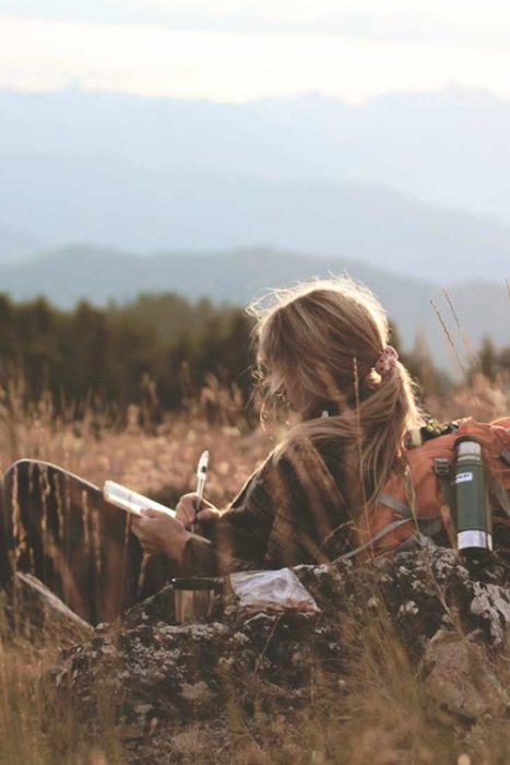 chica en la montaña escribiendo