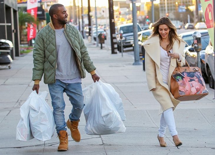 hombre carga bolsas de shopping a mujer en la calle 
