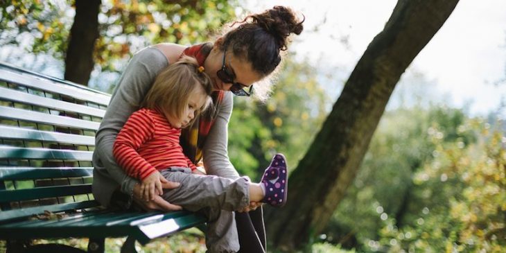 mujer con niña en banca del parque