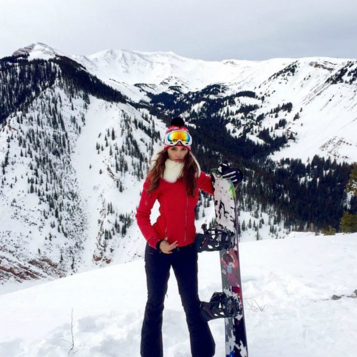 mujer en las montañas nevadas con patineta snowboard 