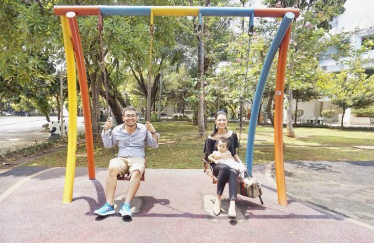 pareja sentada en columpios y bebe 