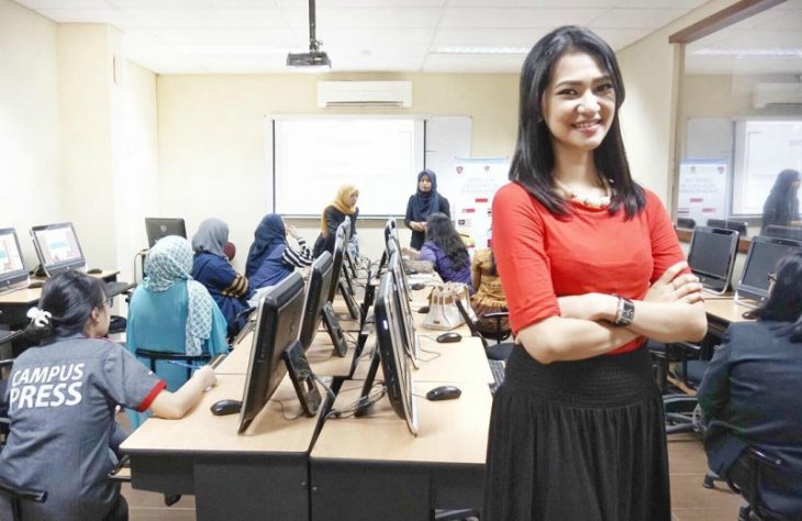 sala de juntas con computadoras y mujer sonriendo blusa roja 