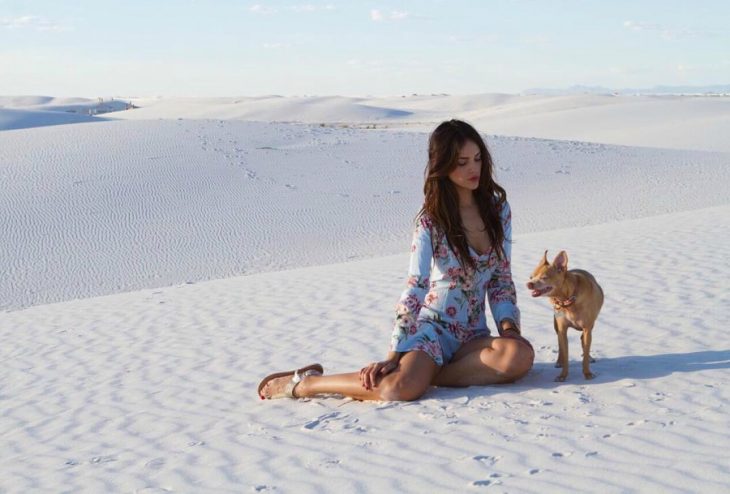 mujer en el suelo con vestido y su perro 