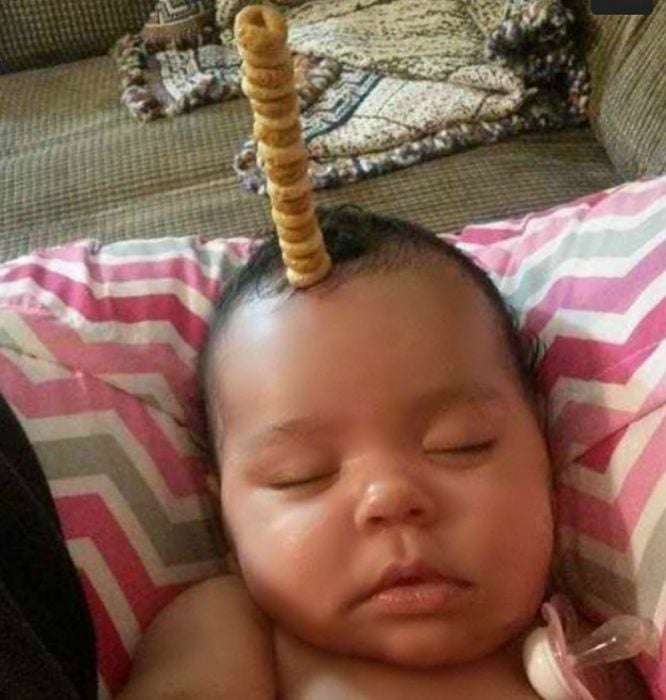 pequeño bebé dormido con pila de cereal en su frente