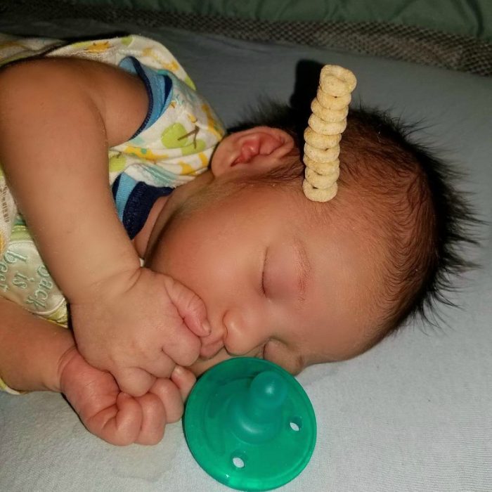 pequeño bebé dormido con pila de cereal en su frente