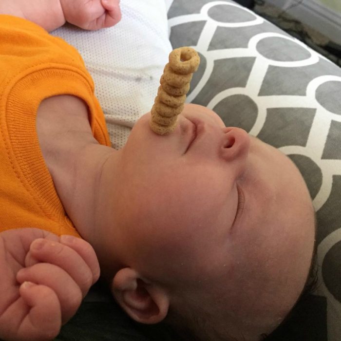 pequeño bebé dormido con pila de cereal en su frente