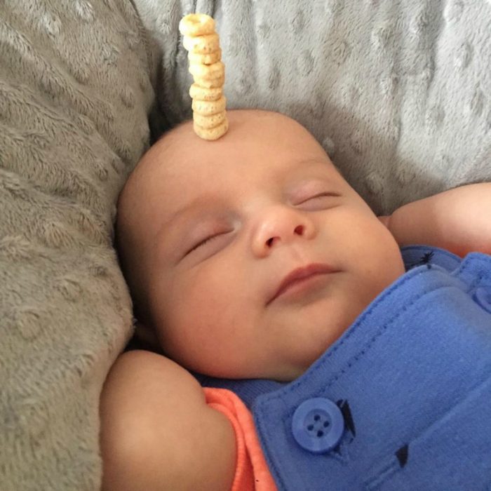 pequeño bebé dormido con pila de cereal en su frente