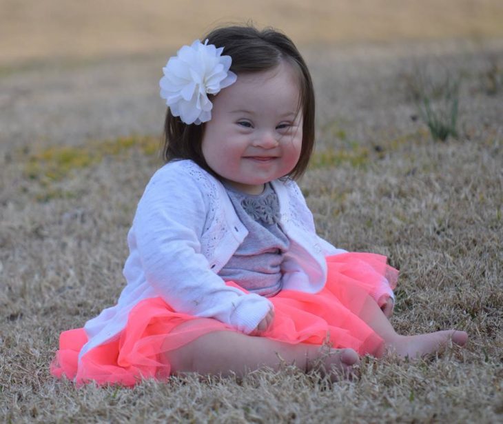 niña con vestido rosa y flor en la cabeza