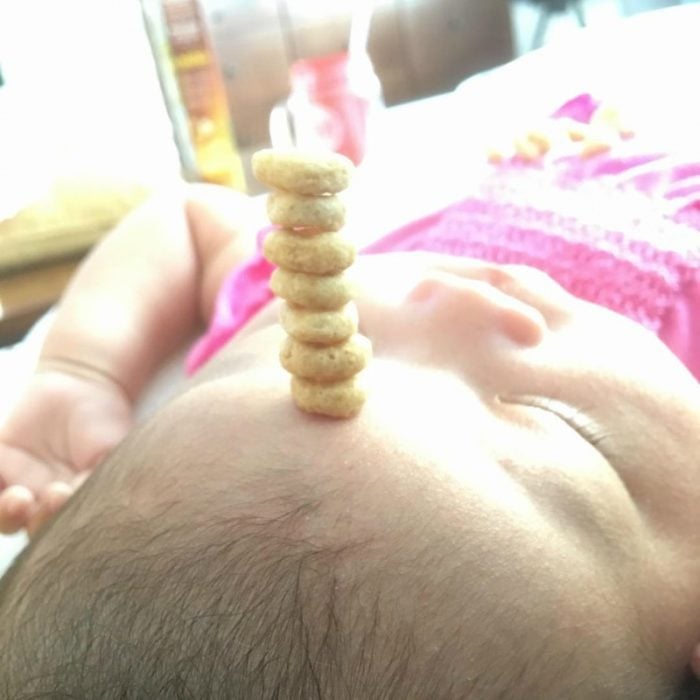pequeño bebé dormido con pila de cereal en su frente