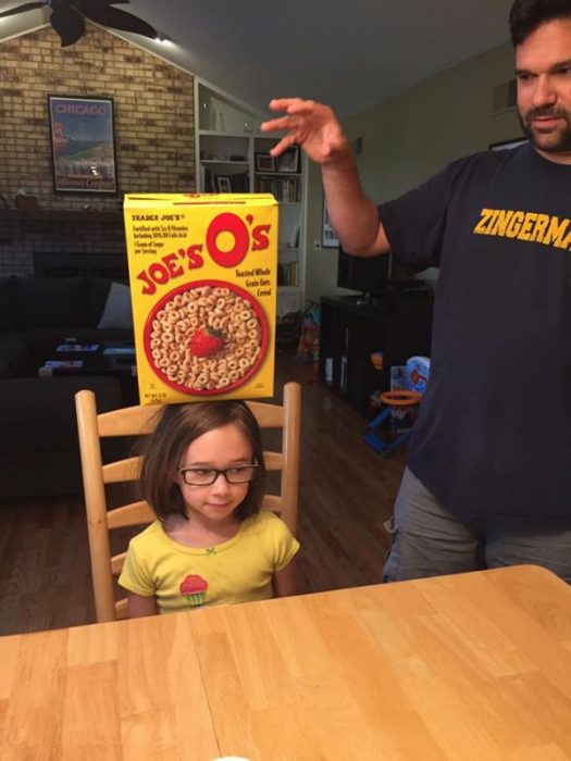 niña con caja de cereal en la cabeza 