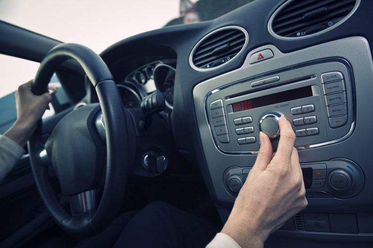 chica bajando volumen de estéreo de coche