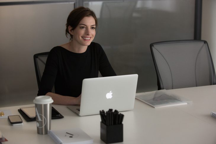 Escena de la película pasante de moda. Anne Hathaway revisando su computadora